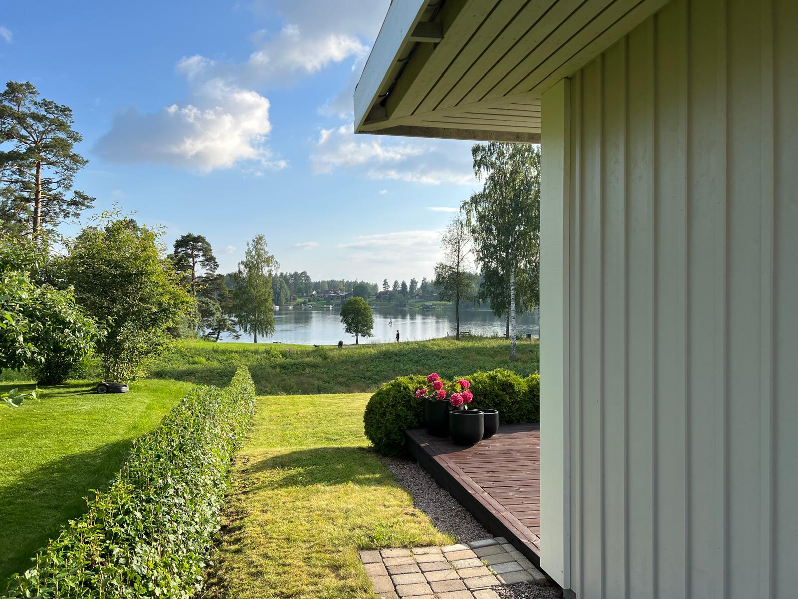 Utsikt från trädgården över häcken mot sjön Runn en sommarkväll